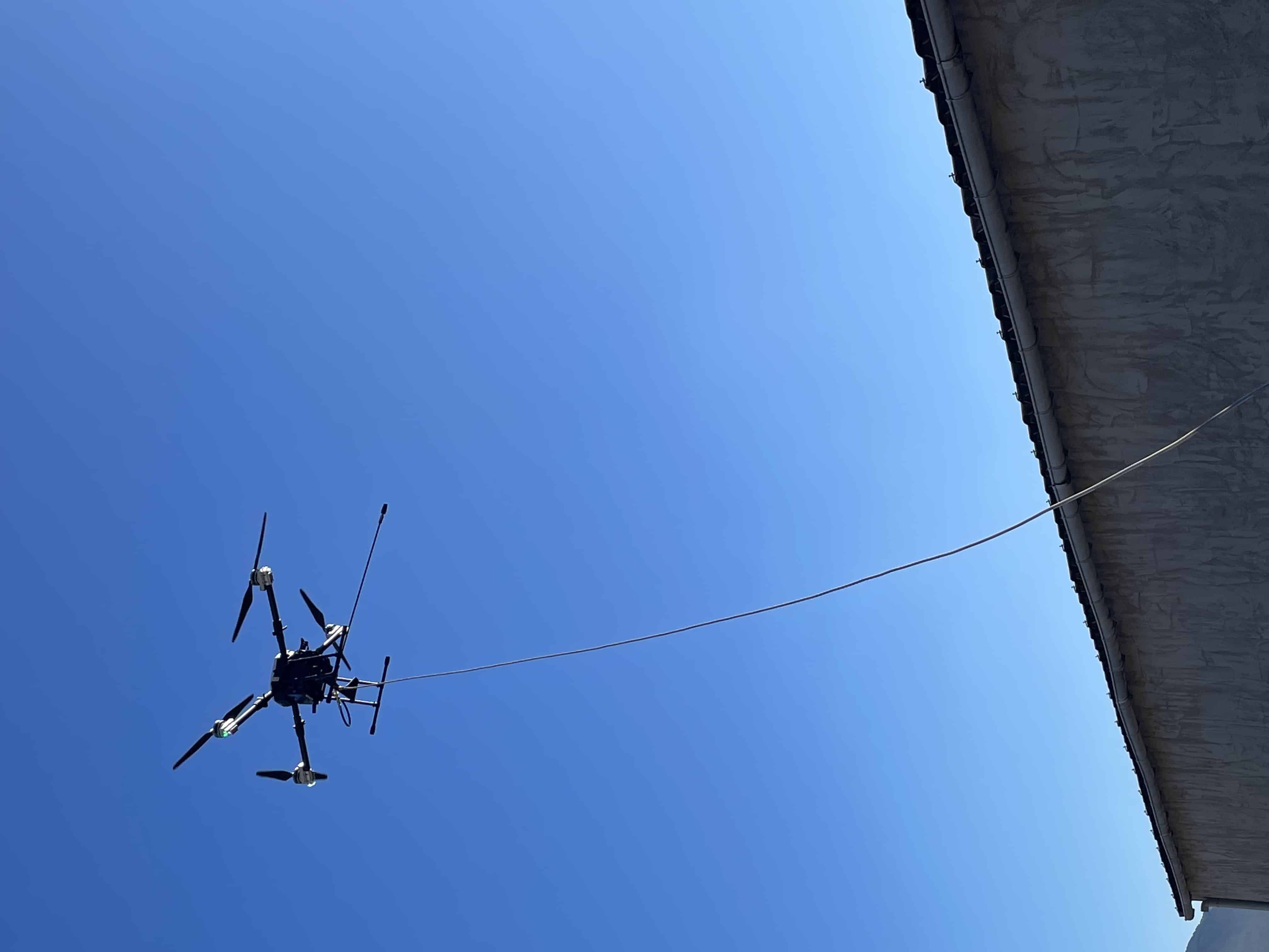 Drone en vol nettoyant une toiture, sans monter sur le toit